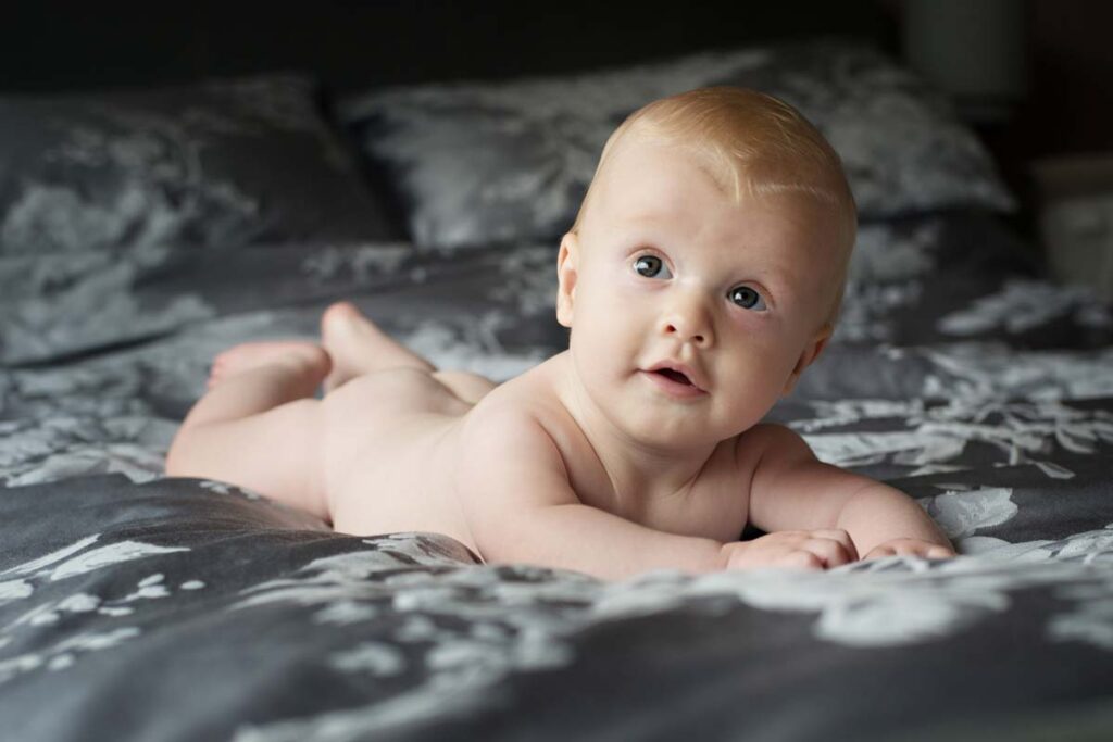 Young baby lying on duvet cover