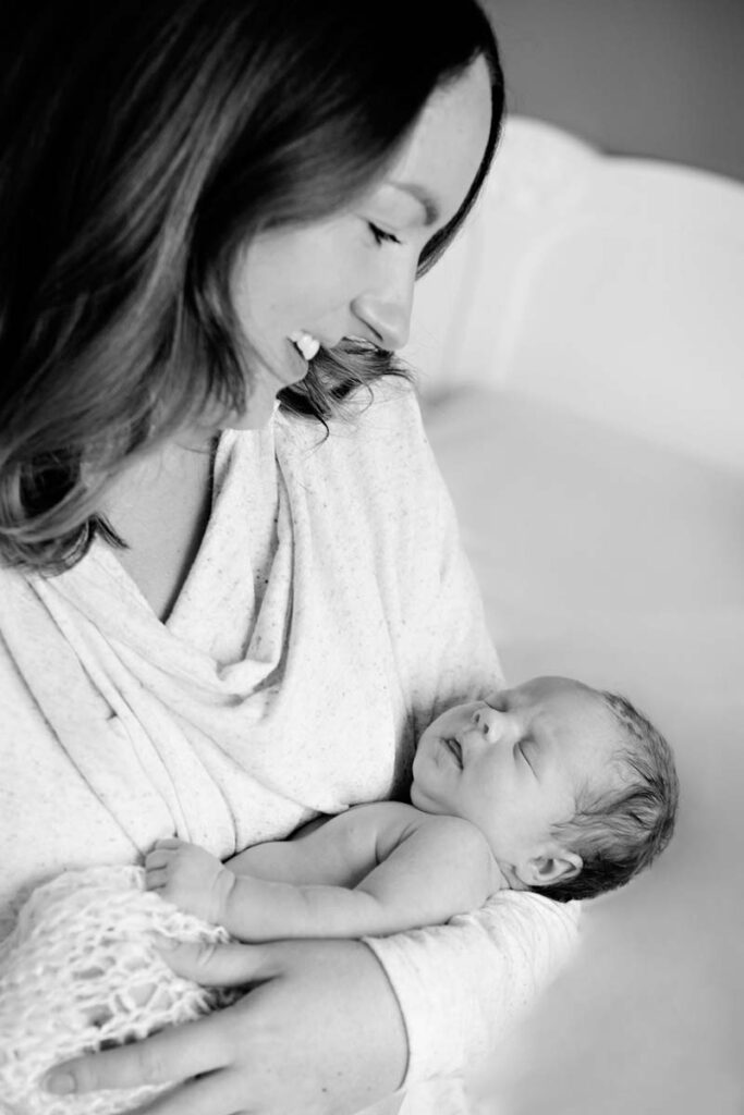 mother looking at newborn baby in her arms