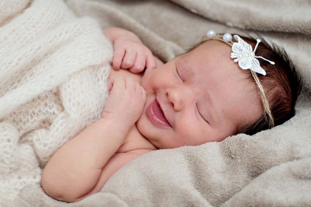 Smiling newborn baby with headband newport pagnell photos