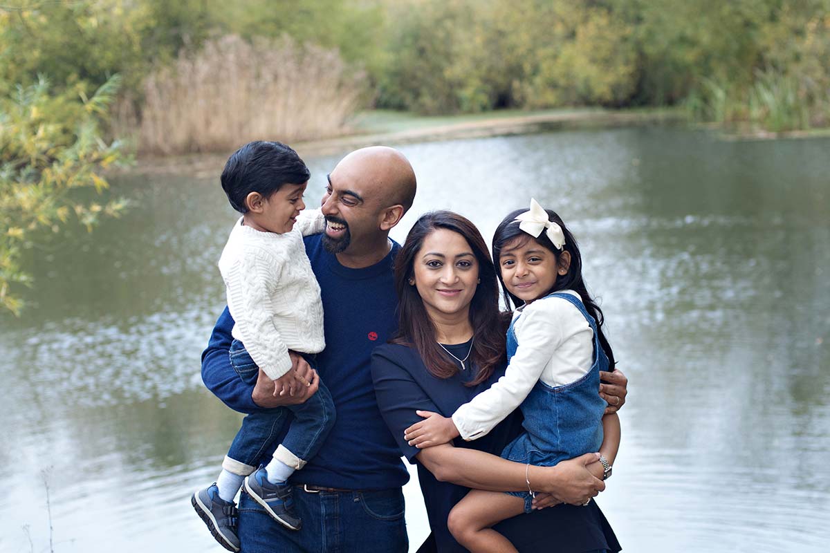 A family of four having their photo taken with the lake as a back drop