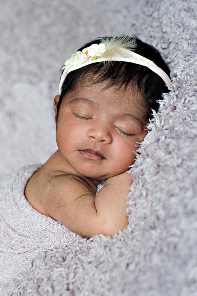 A baby girl with a headband sleeping